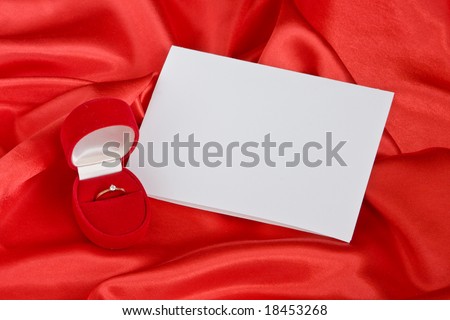 Golden ring in jewel  box  and empty card on red satin