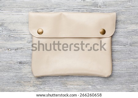 leather clutch bag for tablet on a wooden background