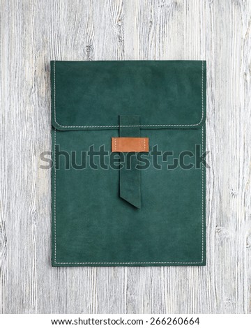 leather clutch bag for tablet on a wooden background
