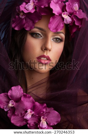 Beautiful girl with orchid flowers in her hair