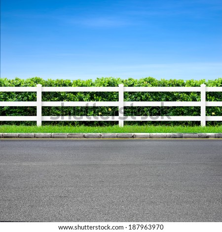 Road side view and white fence on blue sky
