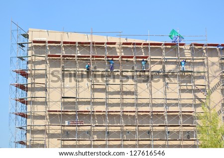 labor working on scaffold in construction site
