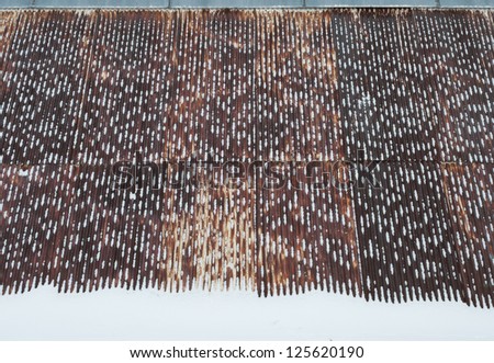 The  vintage rusty iron roof covered with snow