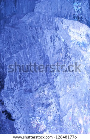 Texture of ice  with dark blue back light. Abstract background.