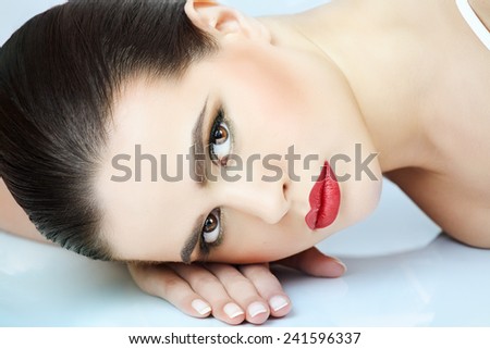 Close-up of a woman with dark hair and eyes lying down.