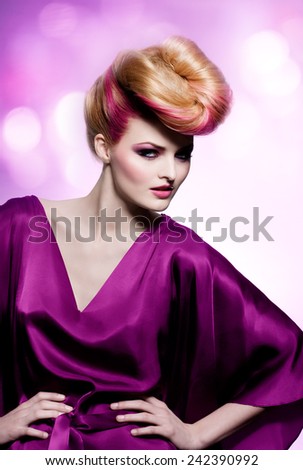 Fashion model with large hairstyle wearing purple silk dress.