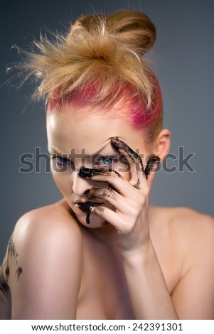 Fashion model with fingers covered in black paint.