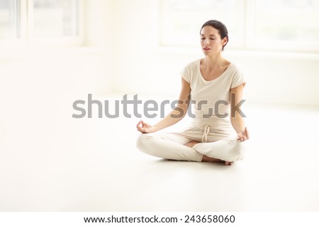 Woman doing yoga in sunny room.