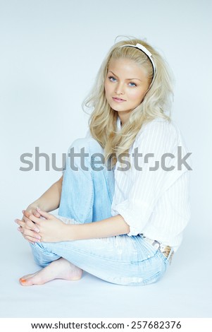 Young blonde woman wearing jeans and white blouse. Some images in the series are shot with tilt-and-shift lens.