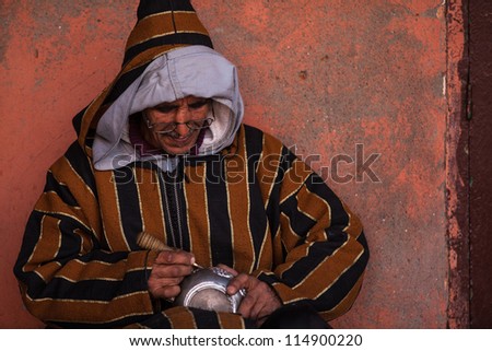 MARRAKESH, MOROCCO - FEBRUARY 24: A Berber man practicing the traditional art of silver engraving in the streets of marrakesh on February 24, 2012 in Marrakesh, Morocco.