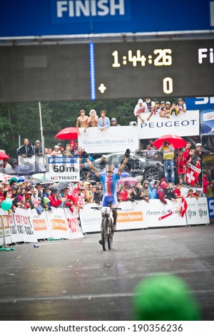 CHAMPERY, SWITZERLAND, SEPTEMBER 21: An unidentified biker raises his arms in victory as he races towards the finish line at the UCI downhill world championships 2011.