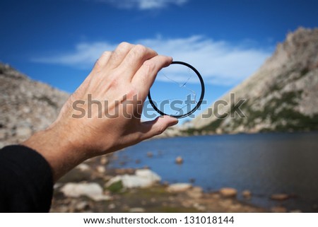 Broken filter to the camera lens on the background of the mountain landscape