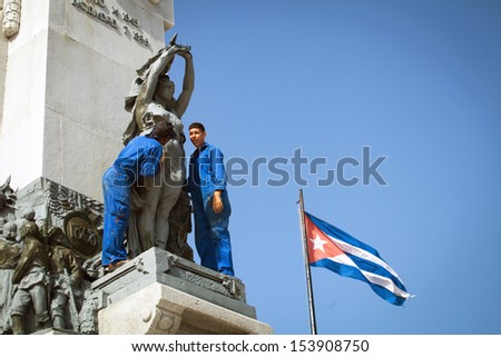 HAVANA, CUBA - JUNE 21: Young people clean monument to heroes of the Cuban Revolution in Havana, Cuba, June 21, 2013