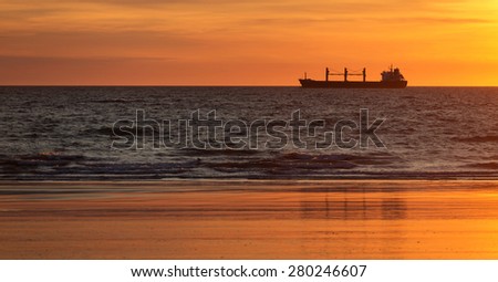 Cargo ships in the ocean at sunset