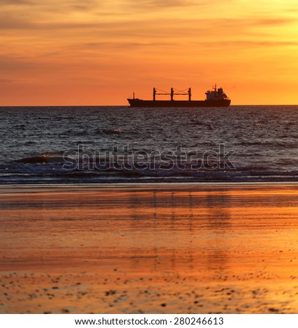 Cargo ships in the ocean at sunset