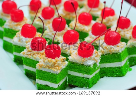 Pandan layer cake cake with 2 layer white cream with cherry on top, selective DOF