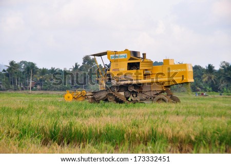 KUANTAN, PAHANG, MALAYSIA - MARCH 9: Unidentified farmer harvesting paddy using machine on March 9, 2013 in Kuantan , Pahang Malaysia. Rice is the staple food in malaysia