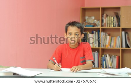 young boy studying with happy face