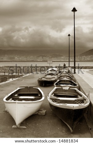 image of some old boats resting in a stormy lead sky