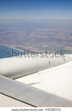 view from the window of a plane of the wing, the sky, the sea and the land
