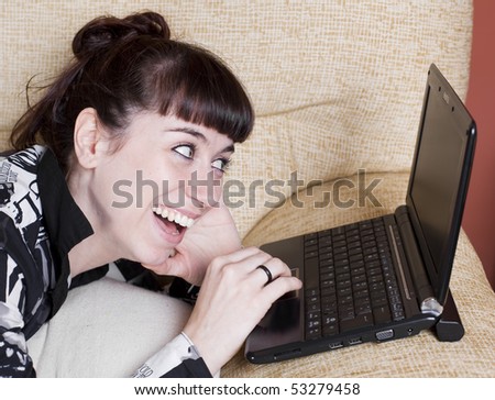 a real young woman typing in the keypad of a laptop