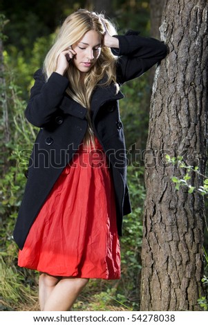 a young beautiful real girl talking with her mobile phone in the nature