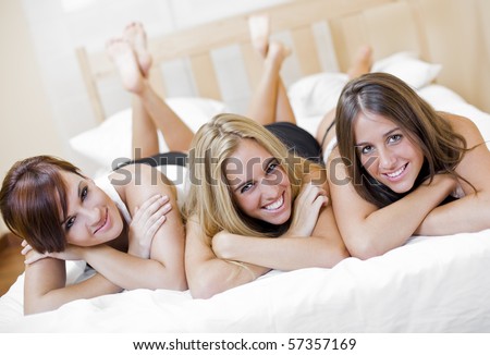 three young beautiful sexy friends playing in the bed