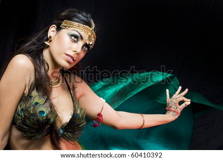 young beautiful oriental woman with a veil dancing over a dark background