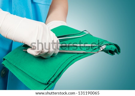 Closeup of dentist hand taking mirror from on of dental tools Closeup of dentist hand taking mirror from on of dental tools