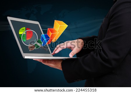 businessman holding a laptop showing business graph on virtual screen