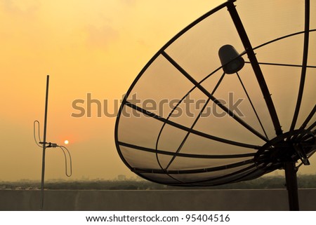 Silhouette of antenna communication satellite dish over sunset sky