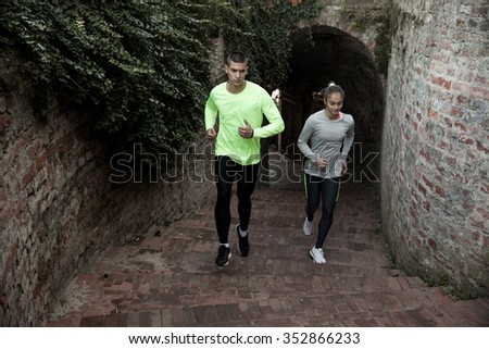 Young man and woman together running upstairs concept for exercising, fitness and healthy lifestyle