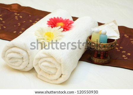bath towels rolled with flower on bed
