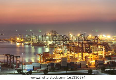 Industrial Container Cargo freight ship with working crane bridge in shipyard at dusk for Logistic Import Export background Industrial Container Cargo freight ship with working crane bridge in shipyard at dusk for Logistic Import Export background