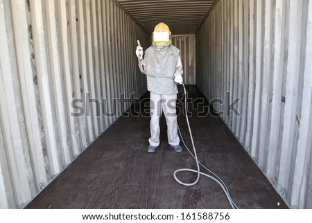 Worker prepare spray painting color inside wall container box steel