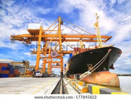 Industrial Container Cargo freight ship with working crane bridge in shipyard with forklif Industrial Container Cargo freight ship with working crane bridge in shipyard with forklif