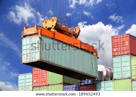 Sea container lifted by a harbor crane with blue sky