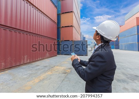 manager shipping company middle aged worker working at container depot with tablet on hand