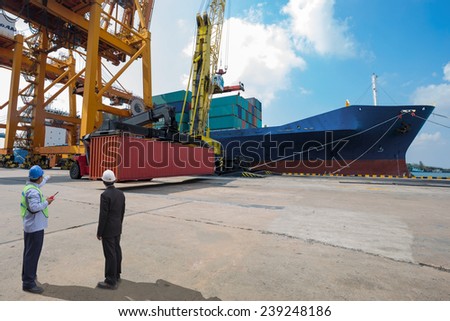 foreman control Industrial Container Cargo freight ship from his manager with working crane bridge in shipyard with truck