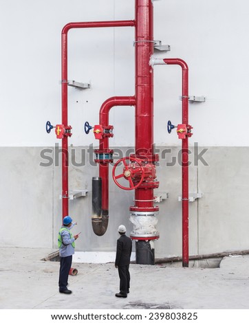 foreman checking connection valves gas structure at warehouse  with his manager
