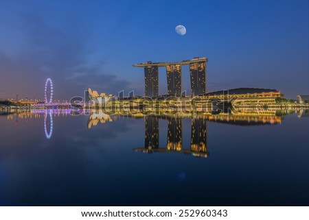 SINGAPORE - April 14: View of the Singapore city skyline at twilight with the moon at twilighttime on April 14, 2014 in Singapore.