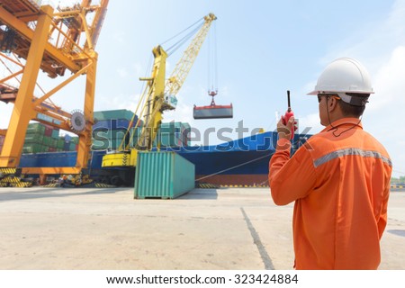 foreman control loading Containers box from Cargo freight ship