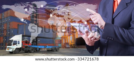 hand presses on world map with digital tablet,Industrial Container Cargo freight ship  in shipyard at dusk for Logistic Import Export background (Elements of this image furnished by NASA)