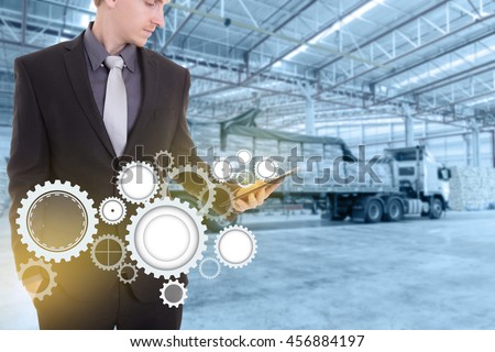 Businessman with tablet on hand , concept supply chain management logistics import export product at large warehouse.