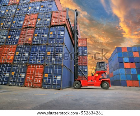 Forklift truck lifting cargo container in shipping yard  for transportation import export business.