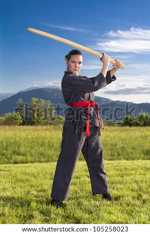 Woman ninja in an aggressive posture with a katana sword