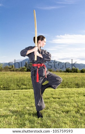 Woman ninja in an aggressive posture    with a sword