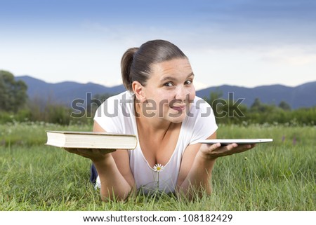 Cute girl in big dilemma: traditional book or modern e-reader - that is the question now