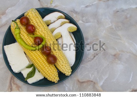 Slices of Boletus Edulis and various colorful tasty seasonal vegetables on marble table  - space for text