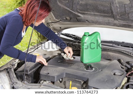 Car maintenance-Woman is cleaning car motor cover after adding oil